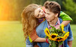 Foto: Loving young man hugging his girlfriend with sunflowers in their Loving young man hugging his girlfriend with sunflowers in their