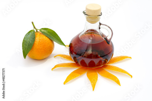 Photo: Bottle of liquor with mandarin isolated on white Bottle of liquor with mandarin isolated on white