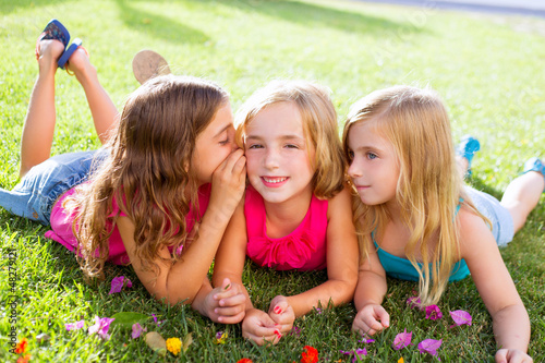 Photo: children girls playing whispering on flowers grass children girls playing whispering on flowers grass