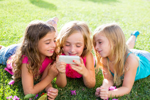 Photo: children friend girls playing internet with smartphone children friend girls playing internet with smartphone