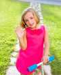 child happy girl playing with scooter in garden