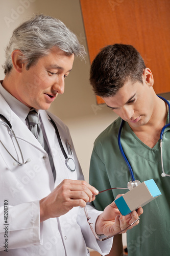 Photo: Medical Professionals Looking At Medicine Box Medical Professionals Looking At Medicine Box