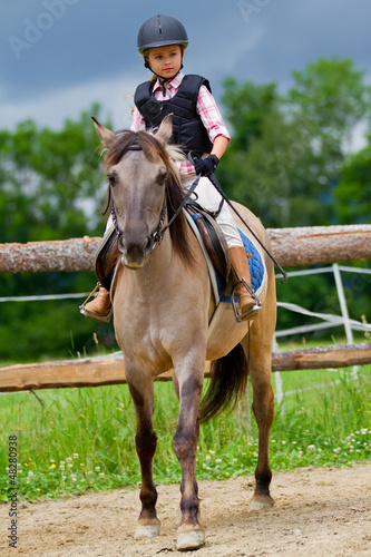 Photo: Horse riding - lovely girl is riding on a horse Horse riding - lovely girl is riding on a horse