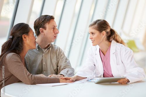 Photo: Female Doctor Using Digital Tablet Talking With Patients Female Doctor Using Digital Tablet Talking With Patients