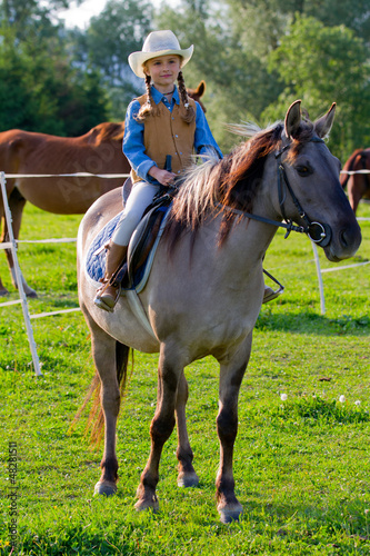 Photo: Horse riding - lovely girl is riding on a horse Horse riding - lovely girl is riding on a horse