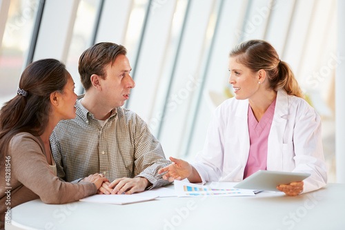 Photo: Female Doctor Using Digital Tablet Talking With Patients Female Doctor Using Digital Tablet Talking With Patients