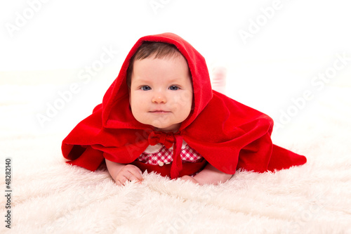 Photo: Baby Little Red Riding Hood on white fur Baby Little Red Riding Hood on white fur