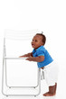 cute african american baby boy learning to walk around a chair