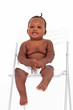 cute african baby boy sitting on white chair
