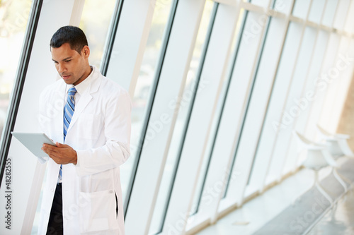 Photo: Doctor Using Digital Tablet In Corridor Of Modern Hospital Doctor Using Digital Tablet In Corridor Of Modern Hospital