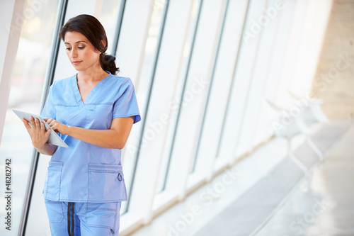 Photo: Nurse Using Digital Tablet In Corridor Of Modern Hospital Nurse Using Digital Tablet In Corridor Of Modern Hospital