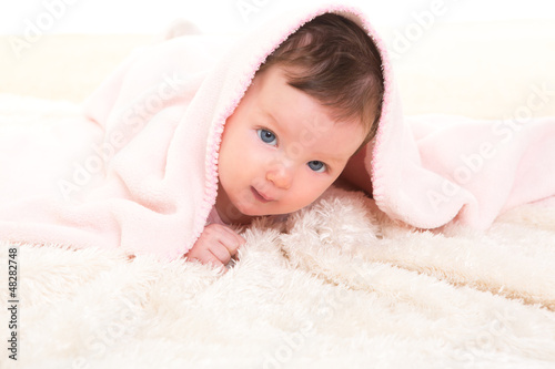 Photo: baby girl under hidden pink blanket on white fur baby girl under hidden pink blanket on white fur
