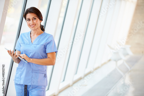 Photo: Nurse Using Digital Tablet In Corridor Of Modern Hospital Nurse Using Digital Tablet In Corridor Of Modern Hospital