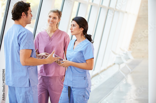Photo: Medical Staff Talking In Hospital Corridor With Digital Tablet Medical Staff Talking In Hospital Corridor With Digital Tablet