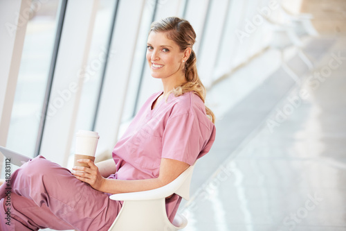 Photo: Female Nurse Using Digital Tablet On Coffee Break In Hospital Female Nurse Using Digital Tablet On Coffee Break In Hospital