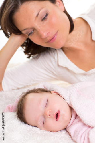 Photo: Baby girl sleeping with mother care near Baby girl sleeping with mother care near