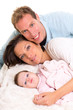 Baby girl mother and father family happy lying together