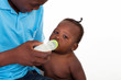 african american father feeding baby boy bottle