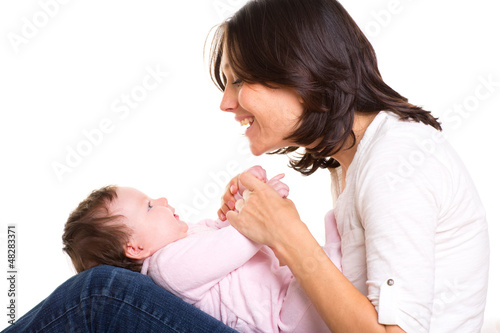 Photo: Baby girl on mother jeans knees playing together Baby girl on mother jeans knees playing together
