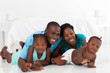 Photo: happy african american family lying on bedroom floor happy african american family lying on bedroom floor