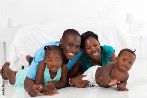 Photo: happy african american family lying on bedroom floor happy african american family lying on bedroom floor