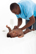 african american father changing baby boy's nappie