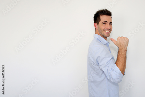 Photo: Cheerful young man showing message on whiteboard Cheerful young man showing message on whiteboard
