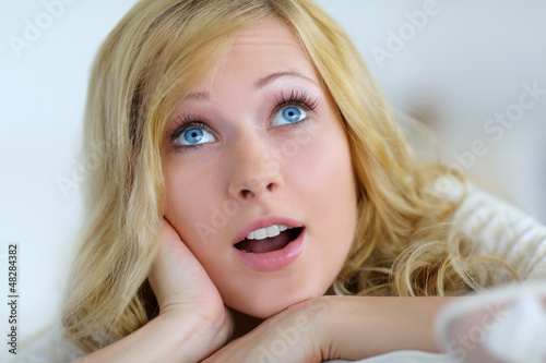Photo: Blond woman with suprised expression looking up Blond woman with suprised expression looking up