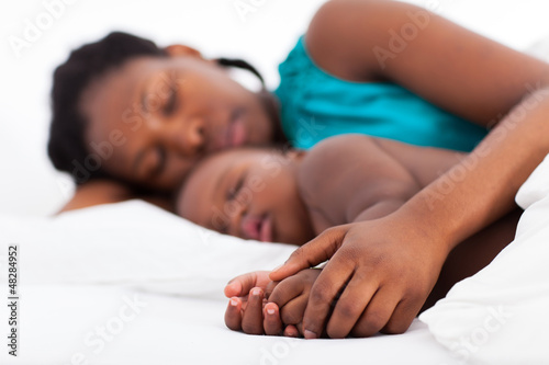 Photo: loving african mother napping with baby boy loving african mother napping with baby boy
