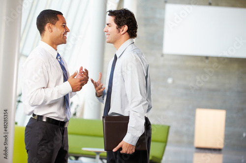 Photo: Two Businessmen Having Informal Meeting In Modern Office Two Businessmen Having Informal Meeting In Modern Office
