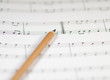 Bleistift liegt auf Musiknoten