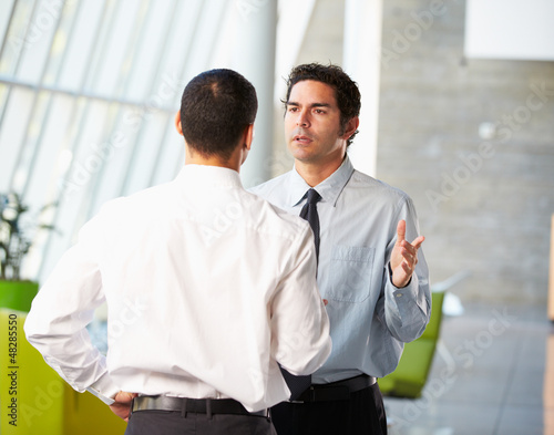 Photo: Two Businessmen Having Informal Meeting In Modern Office Two Businessmen Having Informal Meeting In Modern Office