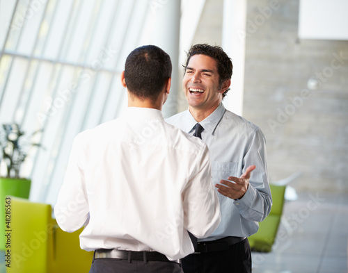 Photo: Two Businessmen Having Informal Meeting In Modern Office Two Businessmen Having Informal Meeting In Modern Office