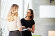Two Businesswomen Having Informal Meeting In Modern Office