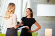 Two Businesswomen Having Informal Meeting In Modern Office