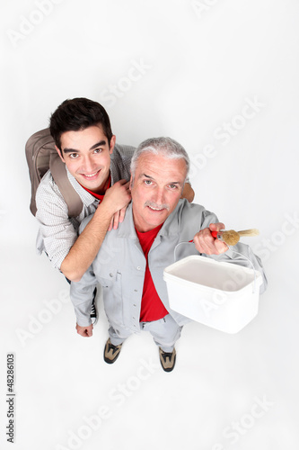 Photo: high angle view of painter and young apprentice high angle view of painter and young apprentice