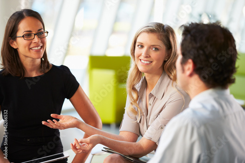 Photo: Businesspeople Having Meeting Around Table In Modern Office Businesspeople Having Meeting Around Table In Modern Office