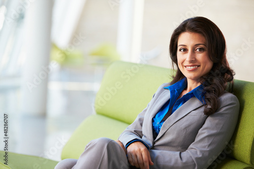 Photo: Portrait Of Businesswoman Sitting On Sofa In Modern Office Portrait Of Businesswoman Sitting On Sofa In Modern Office