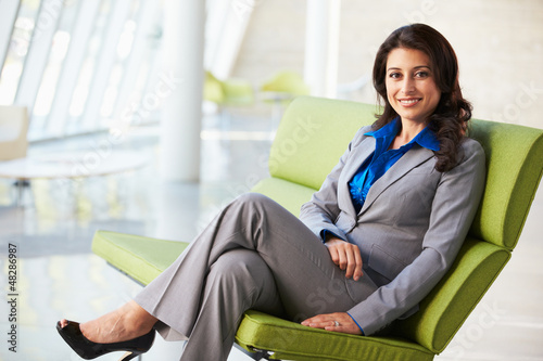 Photo: Portrait Of Businesswoman Sitting On Sofa In Modern Office Portrait Of Businesswoman Sitting On Sofa In Modern Office