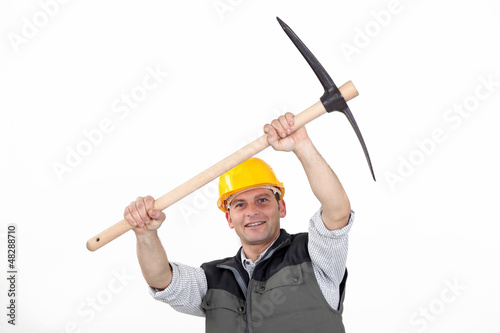 Photo: Construction worker carrying a pickaxe Construction worker carrying a pickaxe
