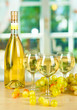 White wine in glass with bottle on window background