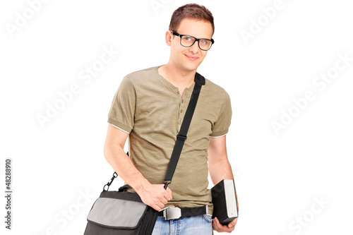 Photo: A male student with shoulder bag holding a book A male student with shoulder bag holding a book
