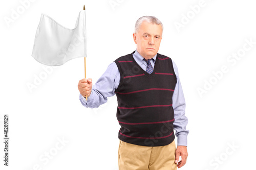 Photo: A sad senior man waving a white flag A sad senior man waving a white flag
