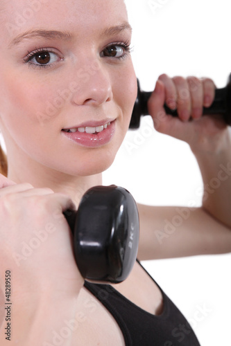 Photo: Young woman lifting dumbbells Young woman lifting dumbbells