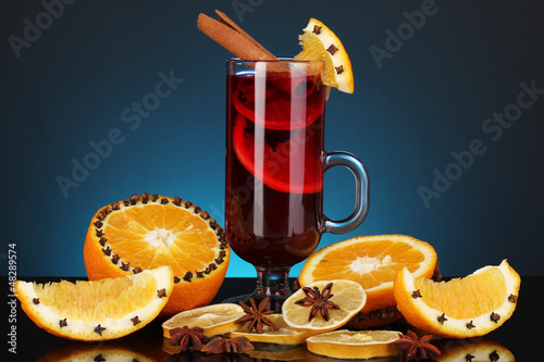 Photo: Fragrant mulled wine in glass with spices and oranges around Fragrant mulled wine in glass with spices and oranges around
