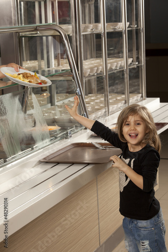 Photo: little girl in cafeteria line trying to take her healthy meal little girl in cafeteria line trying to take her healthy meal