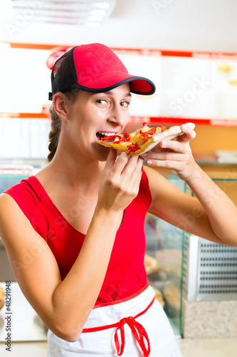 Photo: Woman eating a slice of pizza Woman eating a slice of pizza