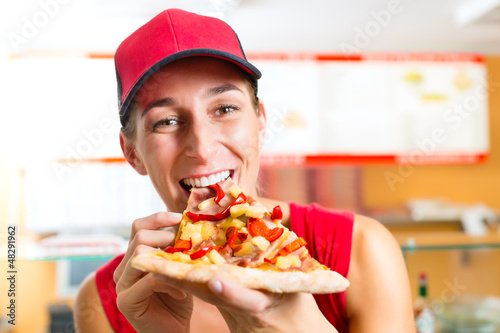 Photo: Woman eating a slice of pizza Woman eating a slice of pizza
