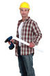 Construction worker holding a plan and a screwdriver