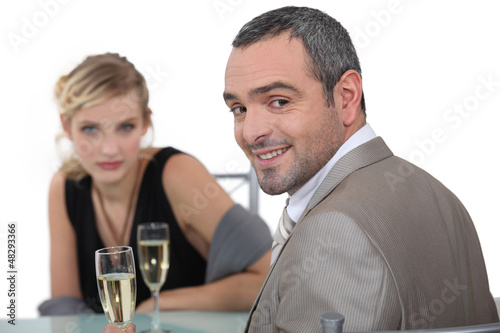 Photo: A nice couple having champagne in a restaurant. A nice couple having champagne in a restaurant.